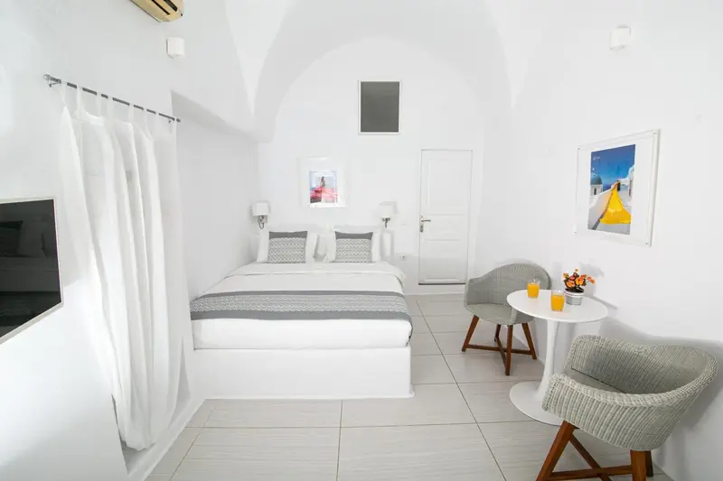 Une chambre lumineuse avec un lit double et un coin salon.