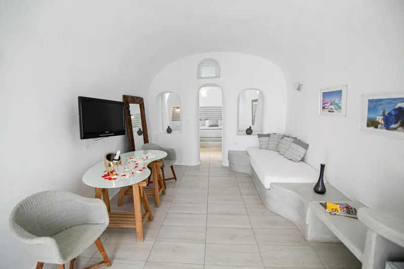 Interieur clair avec un canape, une table et un televiseur.