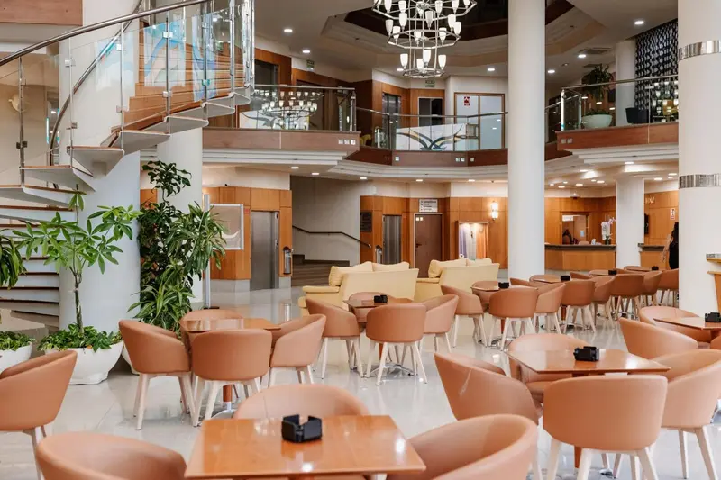 Un hall d'accueil spacieux avec un escalier moderne et des sièges confortables.