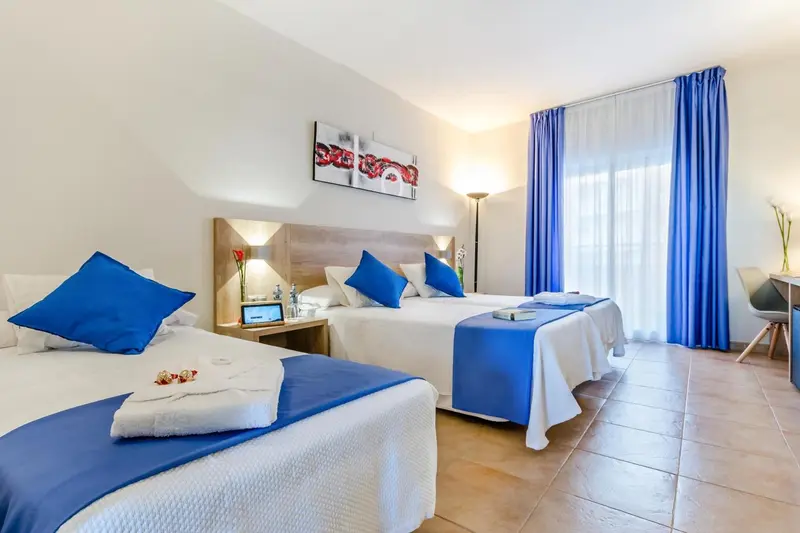Chambre lumineuse avec deux lits simples et une décoration moderne.