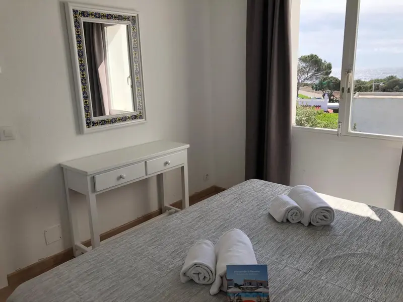 Une chambre lumineuse avec un lit et une coiffeuse.