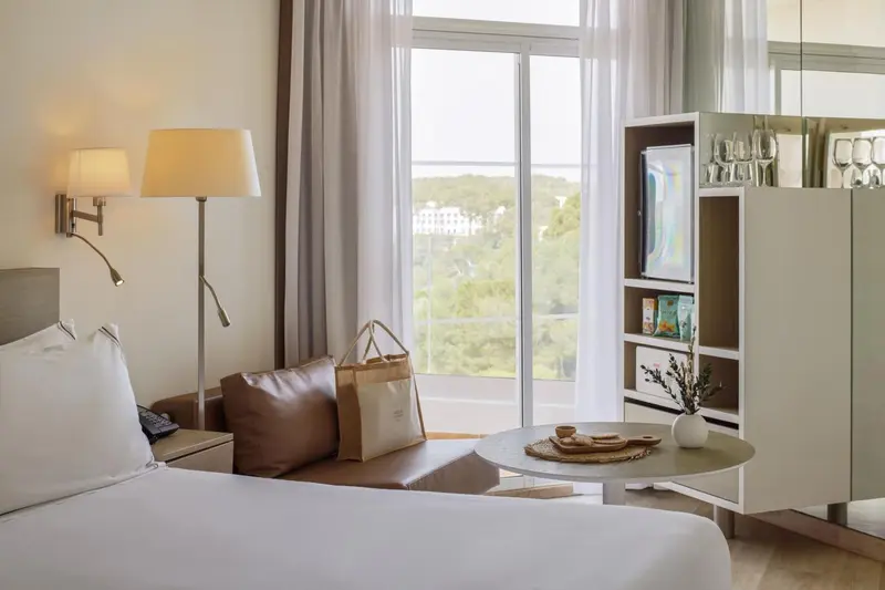 Une chambre lumineuse avec un lit confortable et une vue sur un paysage verdoyant.