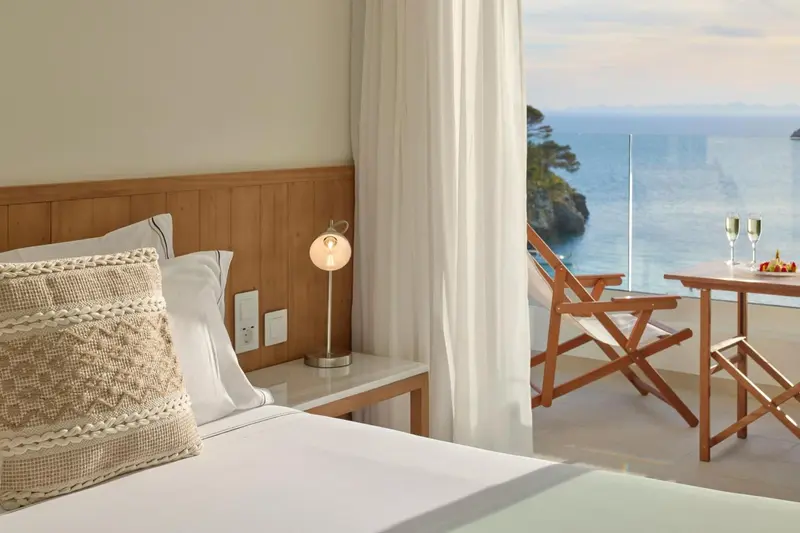 Une chambre lumineuse avec un lit et une vue sur la mer.