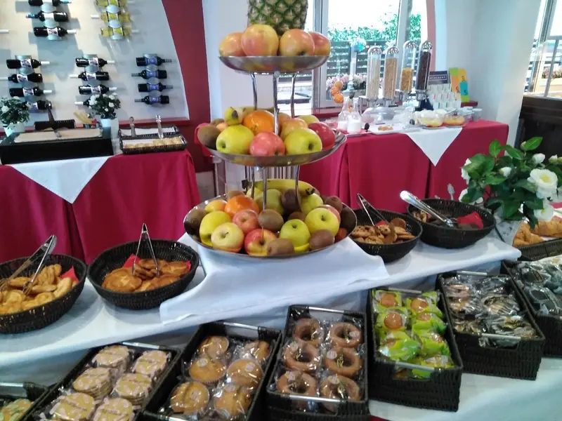 Un buffet propose des fruits frais et des pâtisseries.