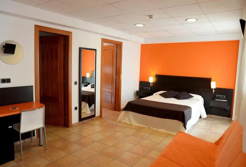 Une chambre d'hôtel moderne avec un lit double et un bureau.