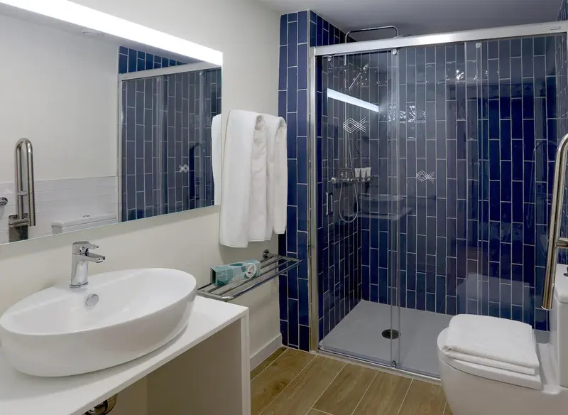 Une salle de bain moderne avec douche à l'italienne et lavabo sur meuble.