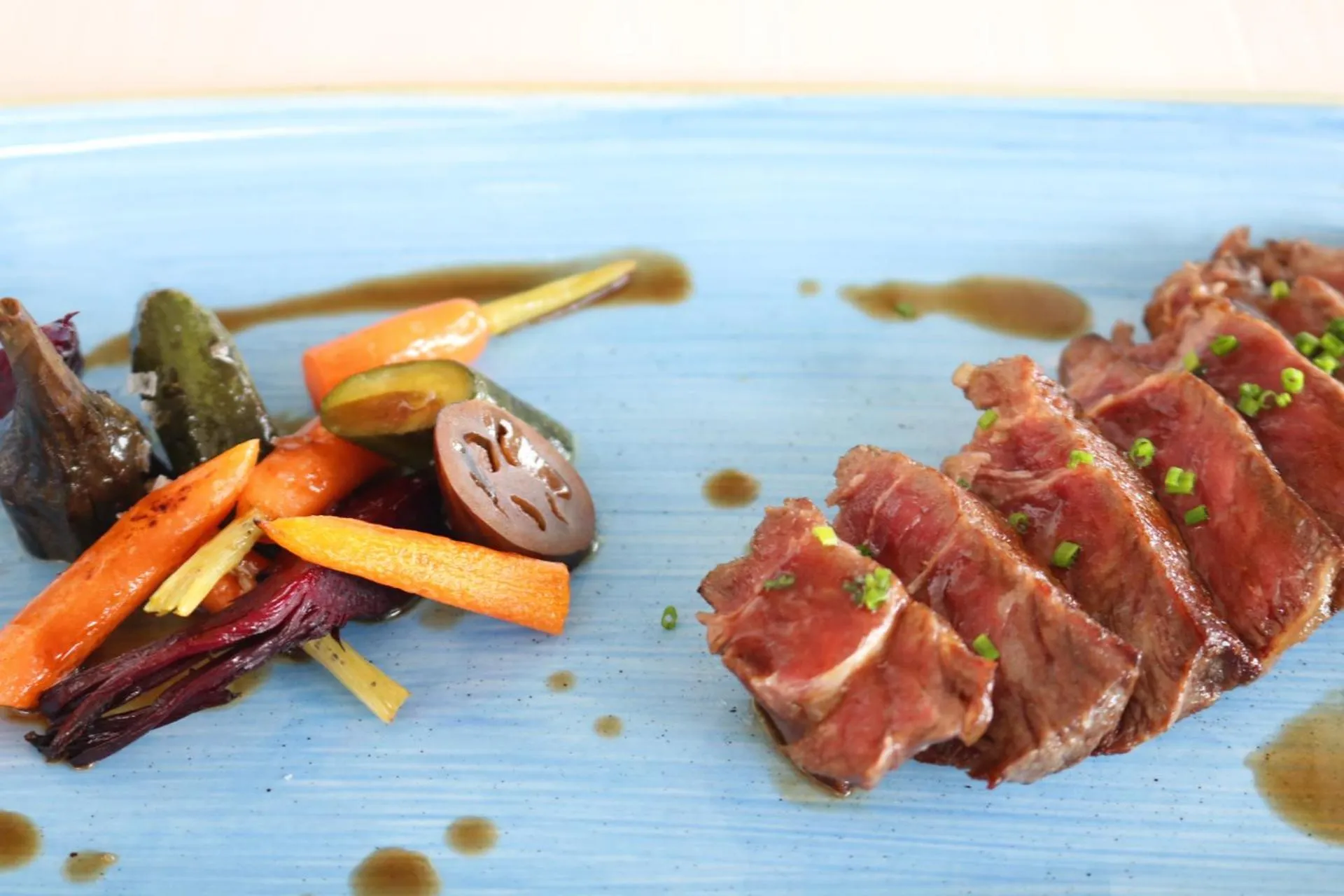 Assiette de viande accompagnée de légumes et d'une sauce.