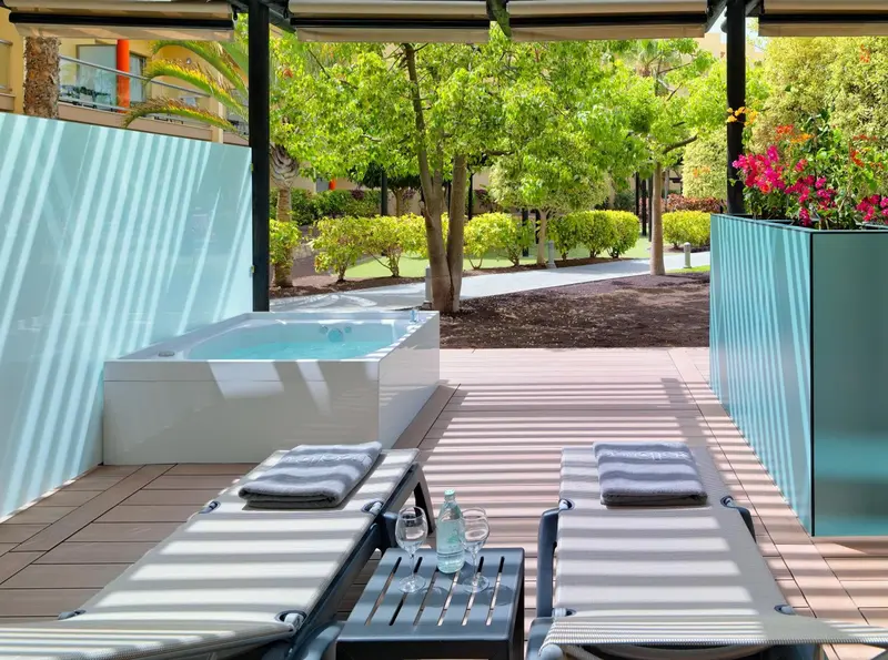 Terrasse avec jacuzzi et chaises longues.