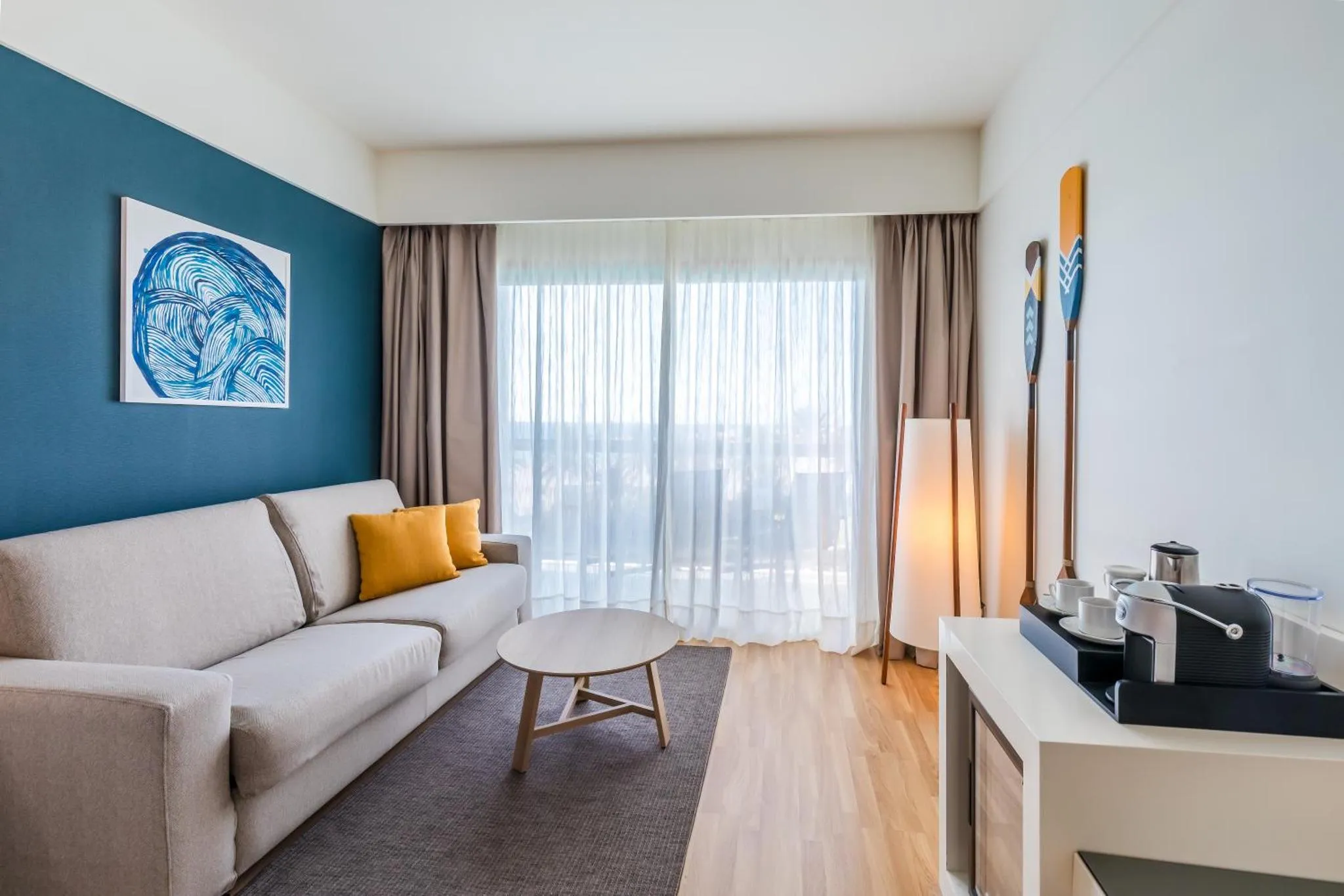 Espace de détente lumineux avec canapé et vue sur la mer.
