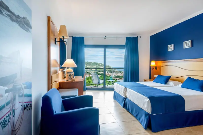 Chambre lumineuse avec vue sur la mer et un coin salon.