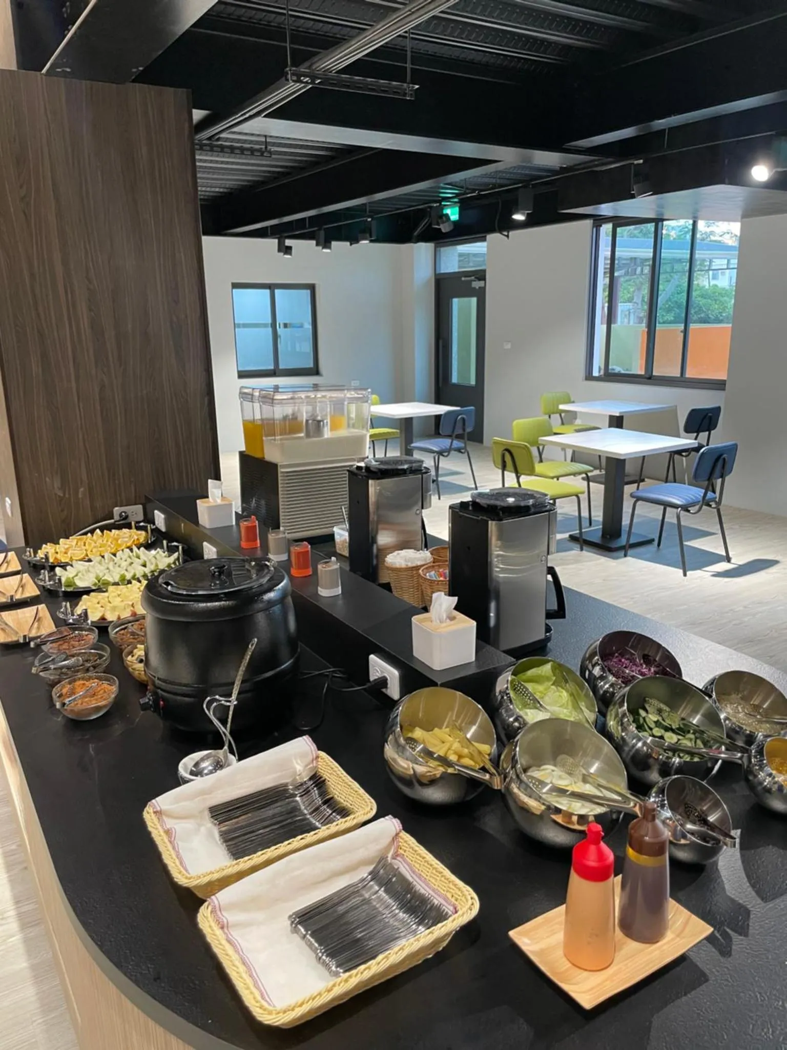 Un buffet propose une variété de plats et de boissons dans une salle lumineuse.