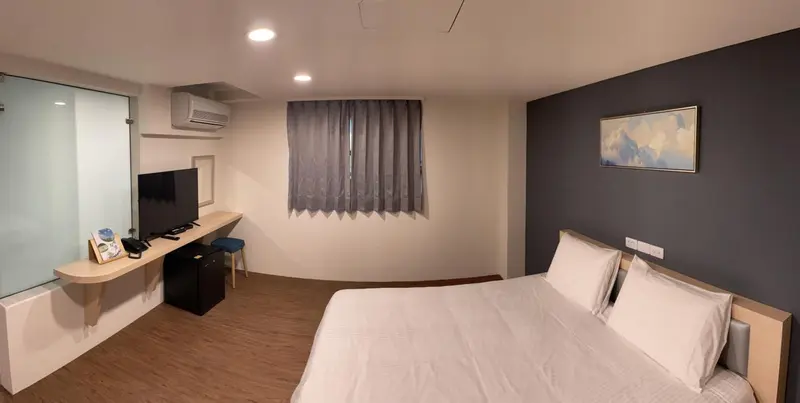 Une chambre d'hôtel moderne avec un lit et un espace bureau.