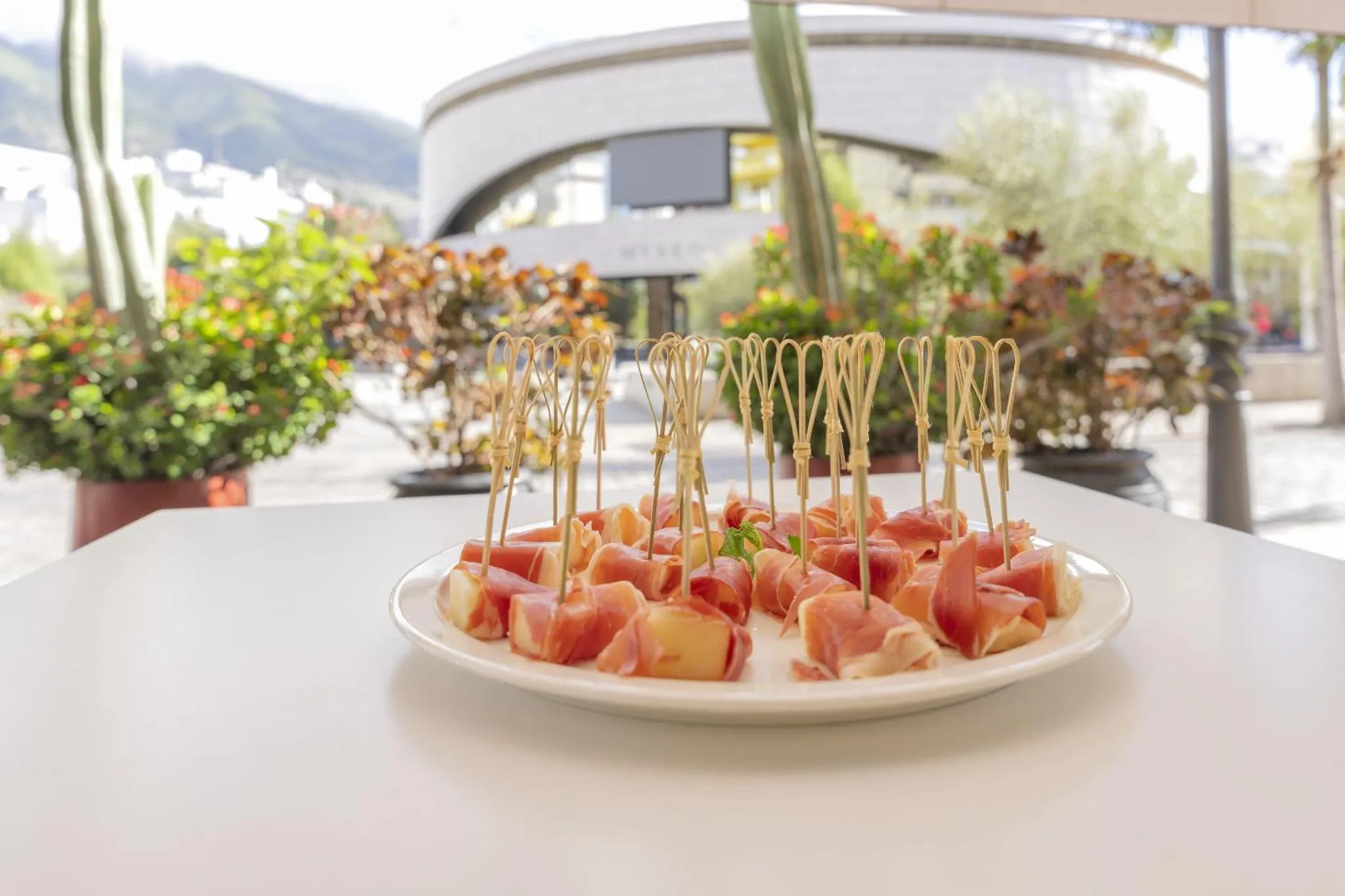 Une assiette de tapas est présentée sur une table en extérieur.