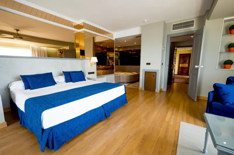 Une chambre lumineuse avec un grand lit et un espace détente.