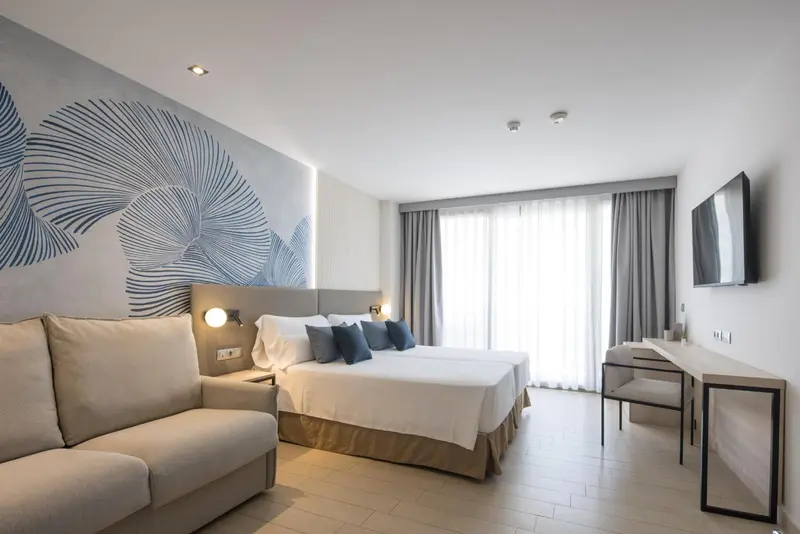 Chambre moderne avec un grand lit et un canapé.