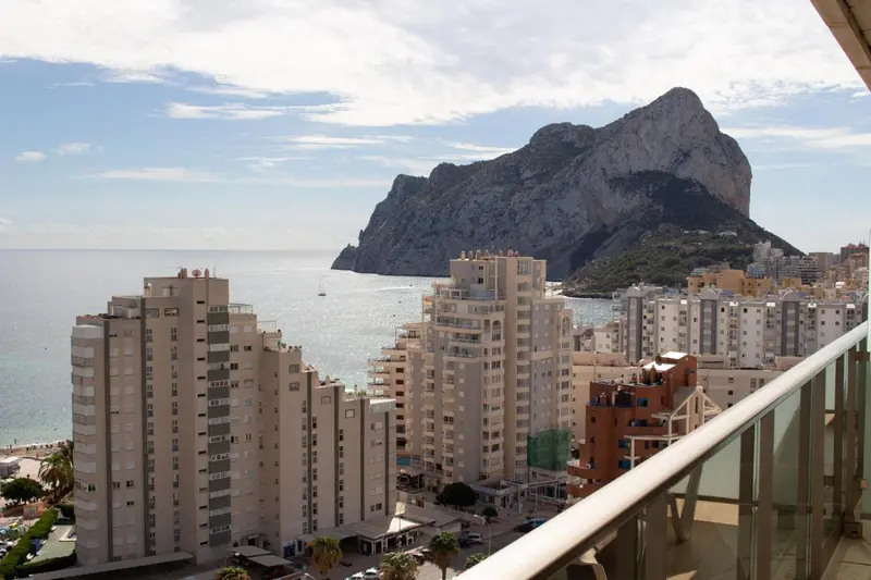 Vue d'ensemble sur une ville côtière et une montagne rocheuse.
