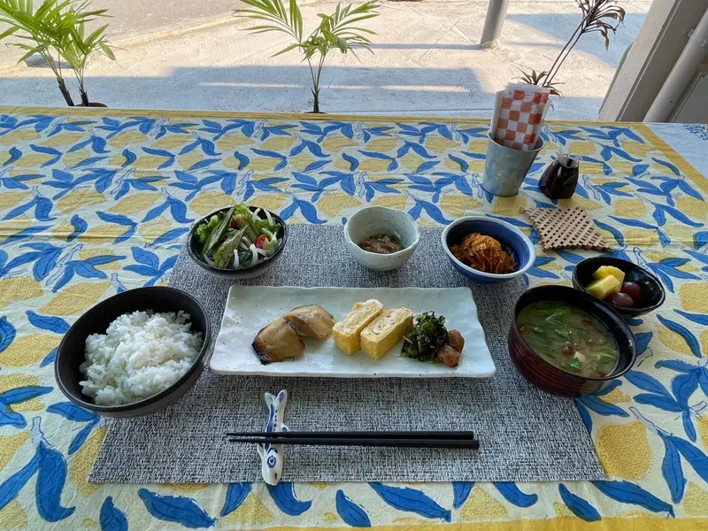 Une table est dressée avec plusieurs plats et couverts.