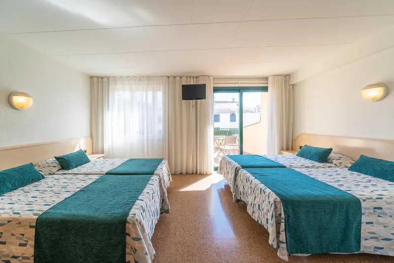 Chambre lumineuse avec deux lits simples et une vue sur l'extérieur.