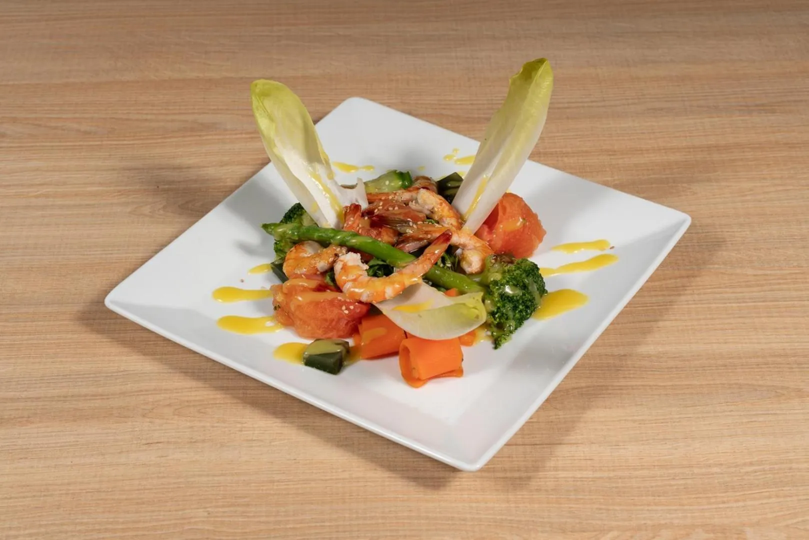 Assiette de fruits de mer et de légumes disposés avec soin.
