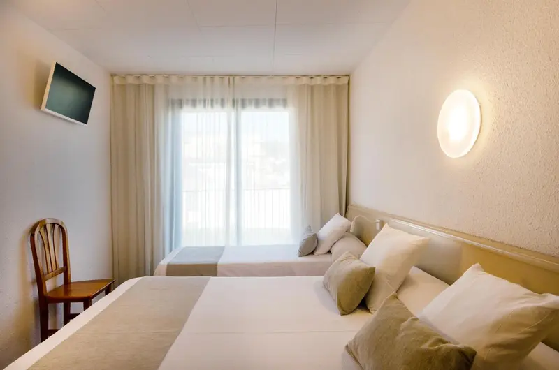 Une chambre lumineuse avec un lit et un accès à un balcon.