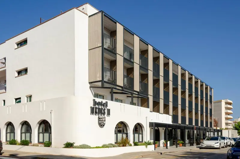 Façade moderne d'un bâtiment blanc à plusieurs étages avec des balcons.