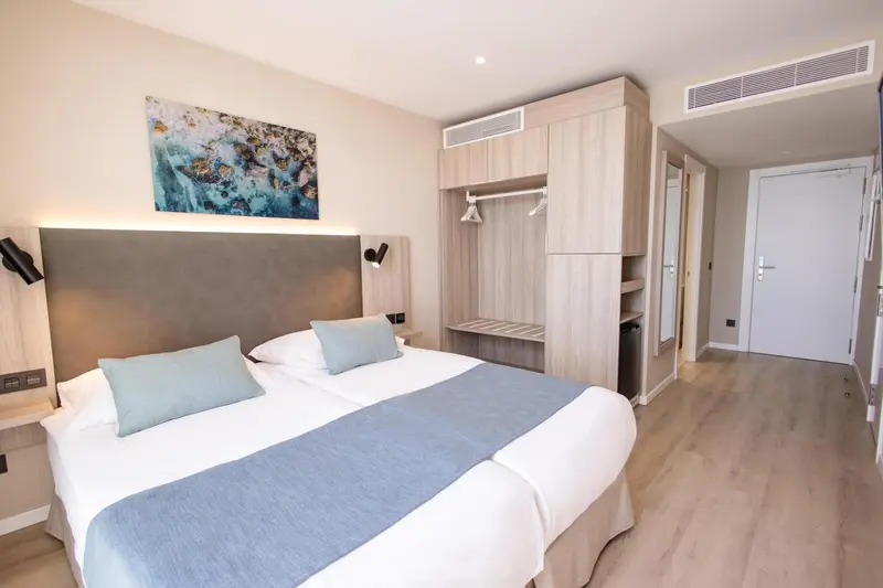 Une chambre lumineuse avec un grand lit et un espace rangement.