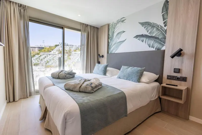 Une chambre lumineuse avec un grand lit et une vue sur la mer.