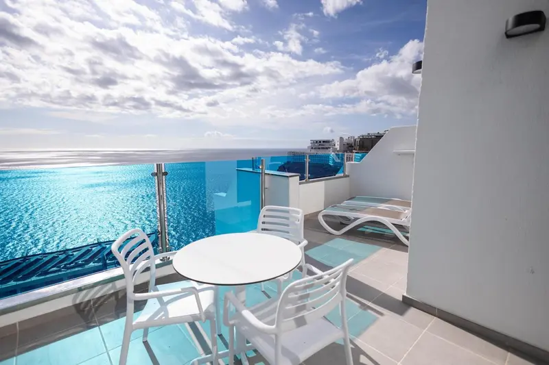 Terrasse avec mobilier blanc donnant sur la mer.