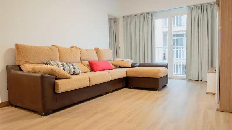 Canapé d'angle beige et marron dans un intérieur clair.