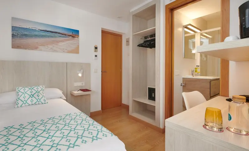 Une chambre lumineuse avec un lit et un espace bureau.