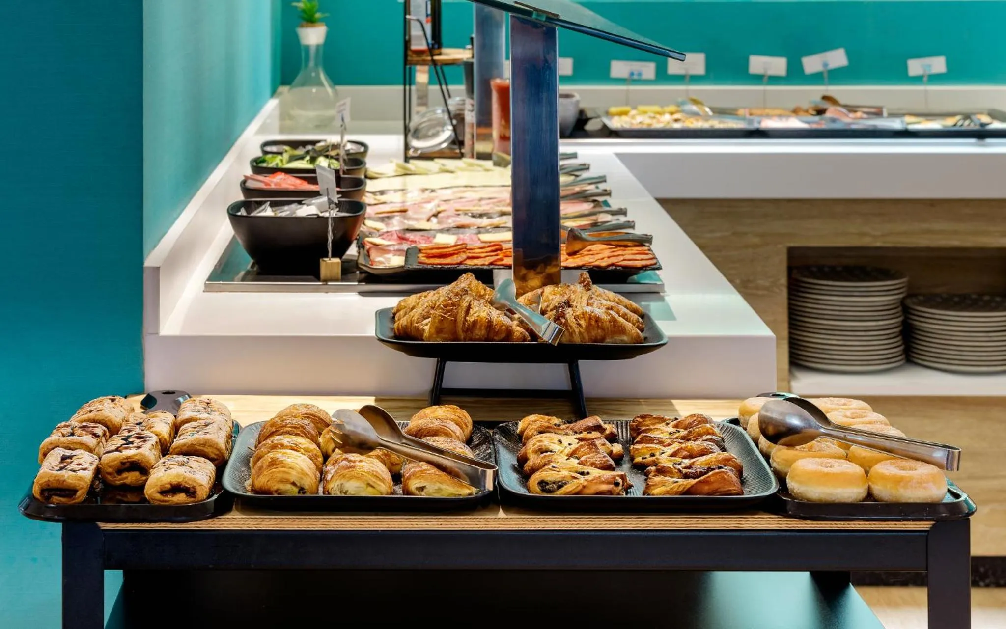 Un buffet propose une variété de viennoiseries et de charcuteries.