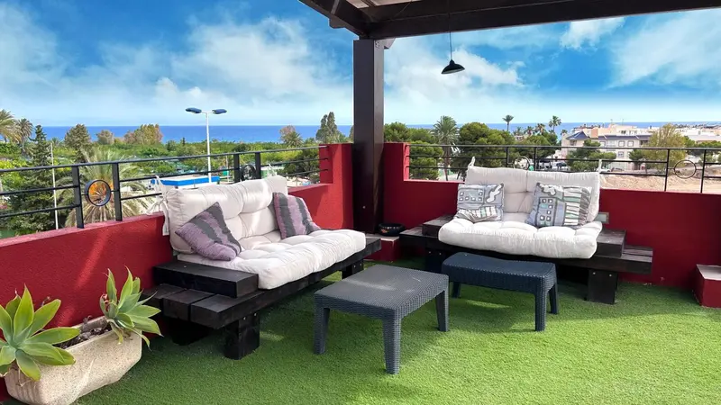 Espace de détente extérieur avec mobilier confortable et vue sur la mer.
