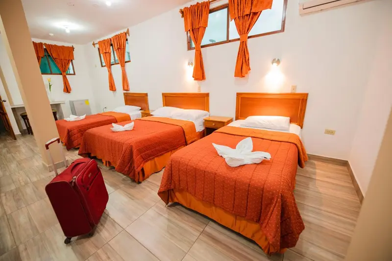 Chambre avec trois lits simples et décoration orangée.