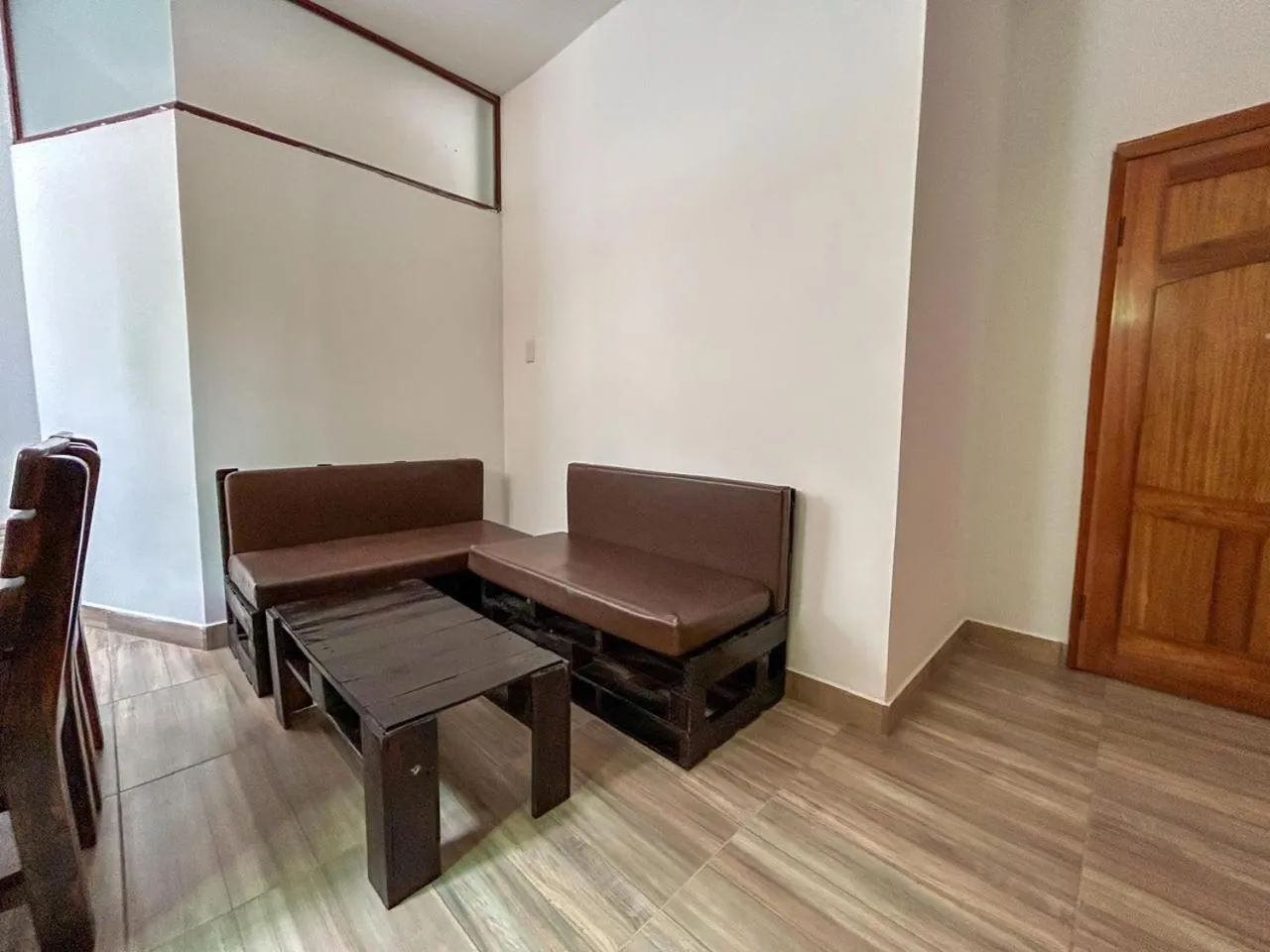 Espace de détente avec canapés en cuir et table basse en bois.