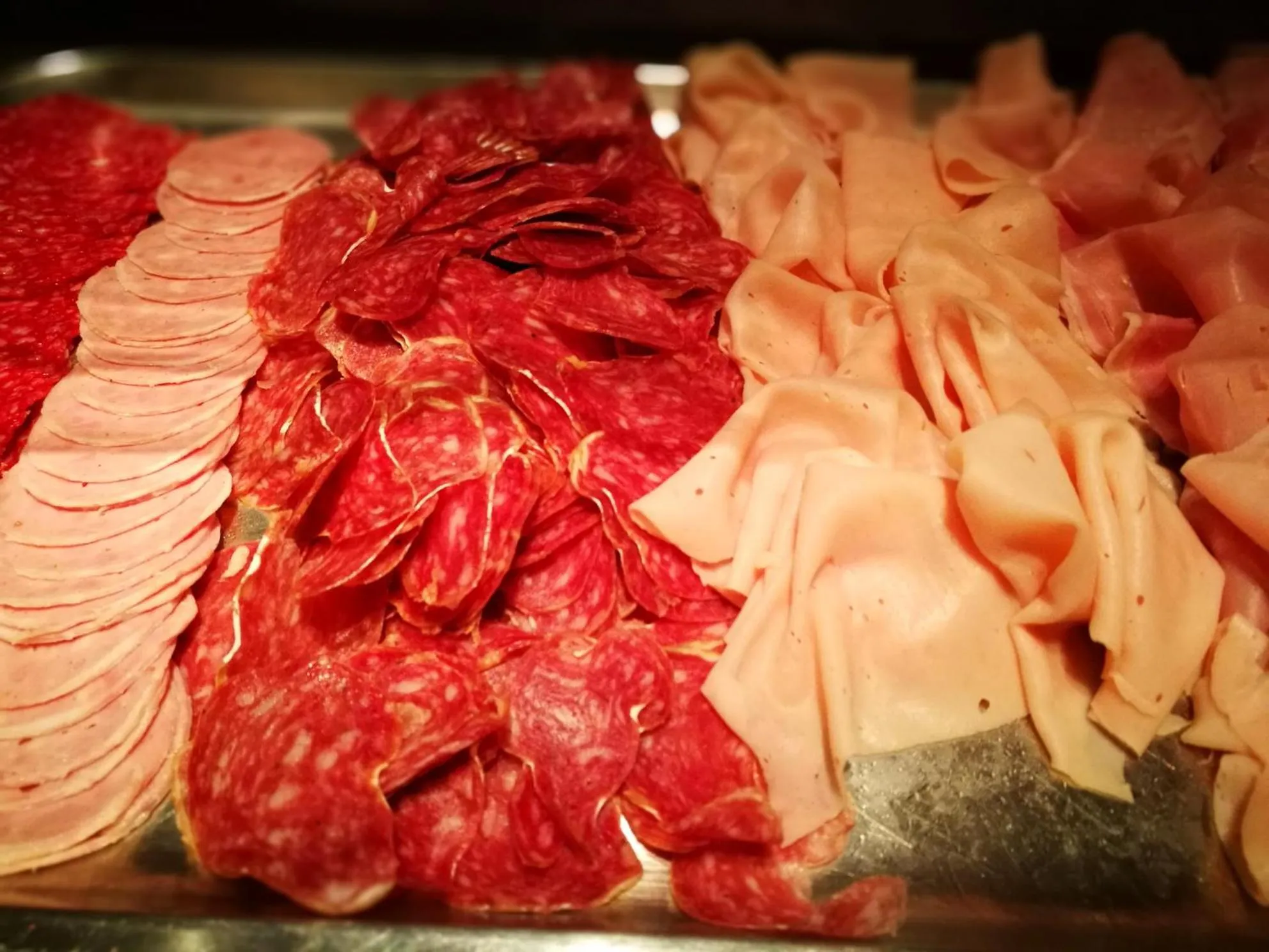 Assortiment de charcuteries disposées sur un plateau.