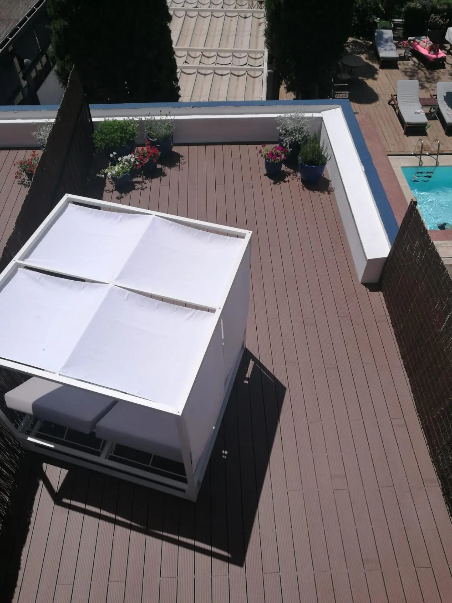 Terrasse aménagée avec mobilier de détente et piscine.