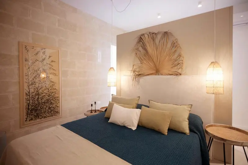 Une chambre à coucher avec un grand lit recouvert de coussins et d'une couverture bleue.