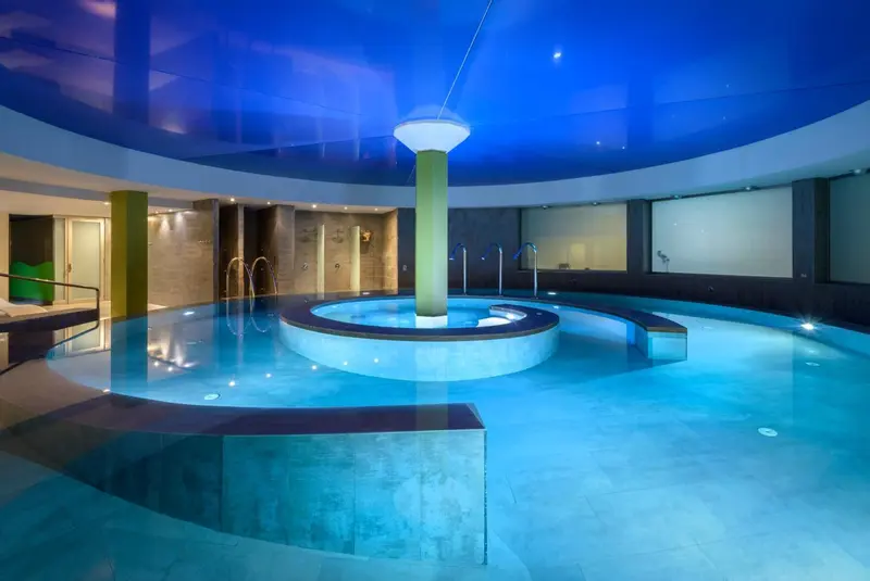 Espace de détente avec piscine intérieure et jacuzzi.