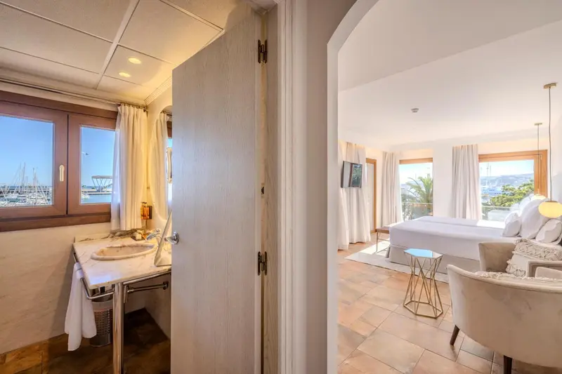 Une chambre lumineuse s'ouvre sur un espace de vie avec vue sur la mer.