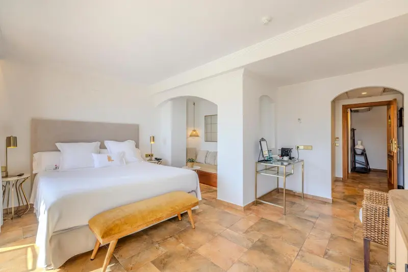 Une chambre lumineuse avec un grand lit et un espace détente.