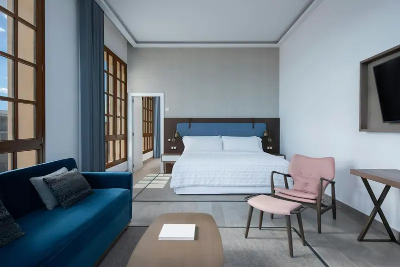 Une chambre lumineuse avec un canapé, une table basse et un lit double.