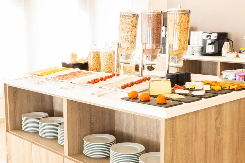 Un buffet propose des céréales, des viennoiseries et des fruits frais.