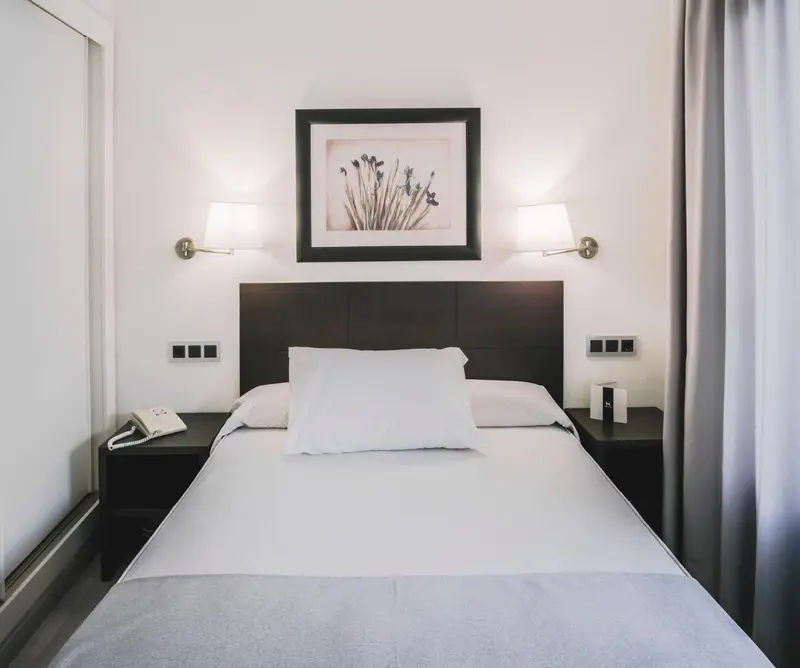 Une chambre avec un grand lit et une décoration sobre.