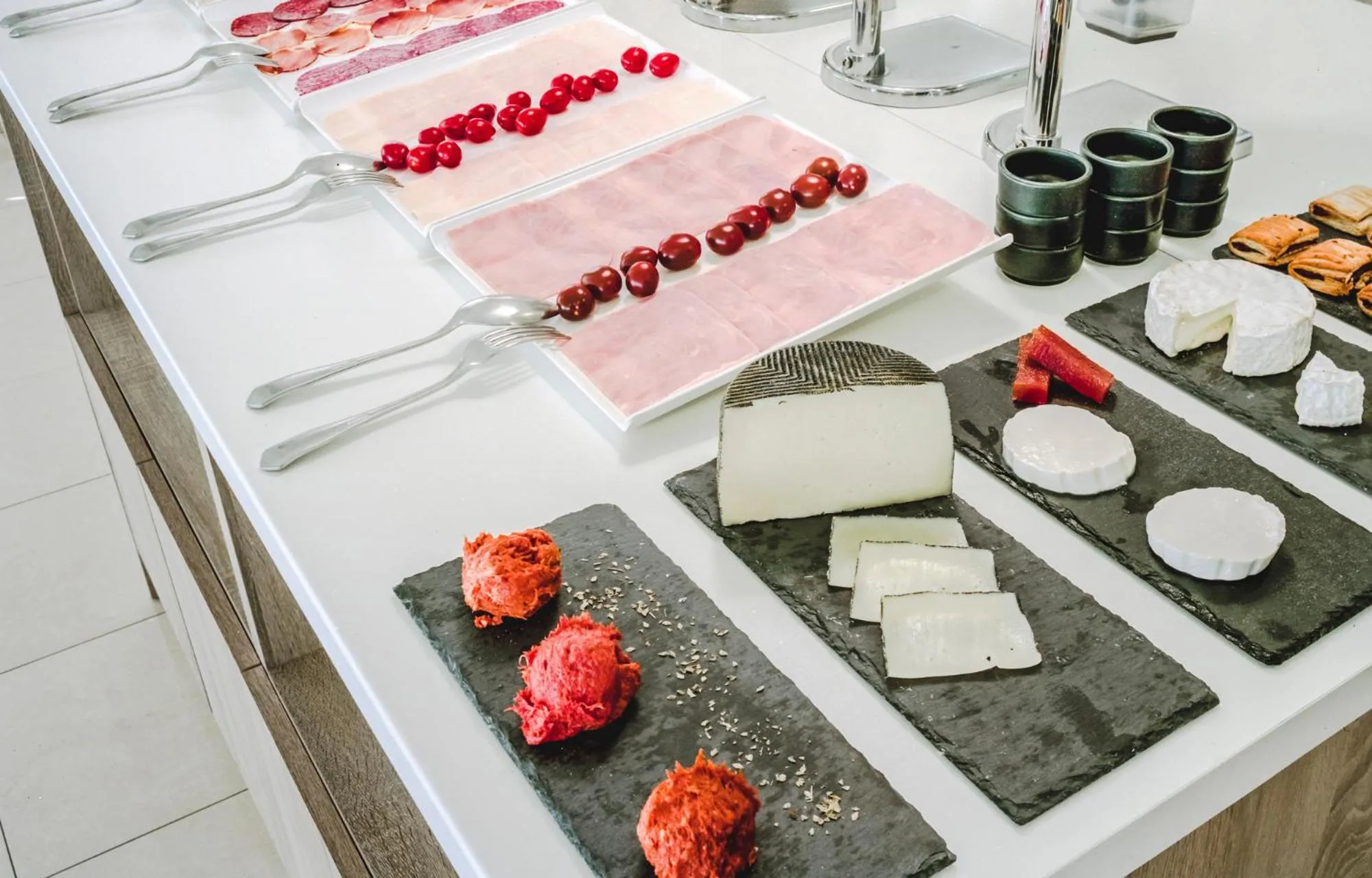 Présentation de charcuterie et de fromages variés sur un buffet.