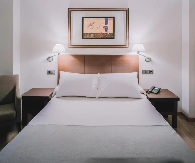 Une chambre d'hôtel avec un grand lit et des tables de chevet.