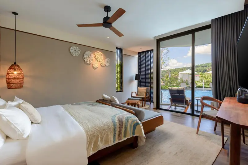 Une chambre lumineuse avec un grand lit et un accès à une terrasse avec vue sur une piscine.