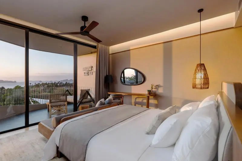 Une chambre lumineuse avec un grand lit et une vue sur la mer.