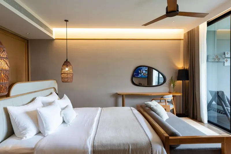 Une chambre lumineuse avec un grand lit et un bureau.