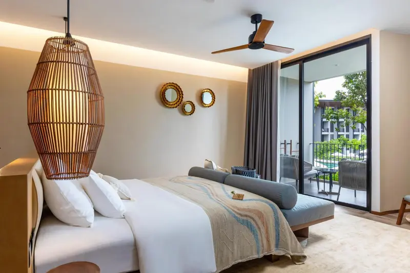 Une chambre lumineuse avec un grand lit et un accès à une terrasse.