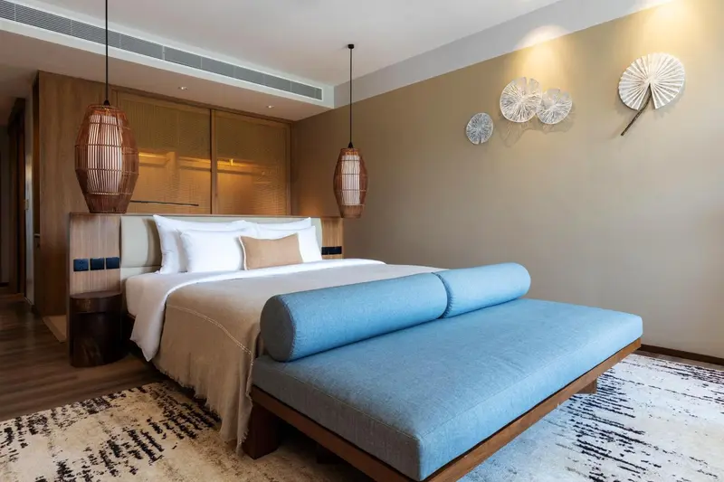 Une chambre lumineuse avec un grand lit et une décoration murale.